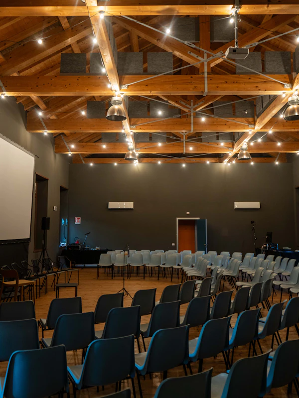 Meeting hall with seating, a projection screen and microphones