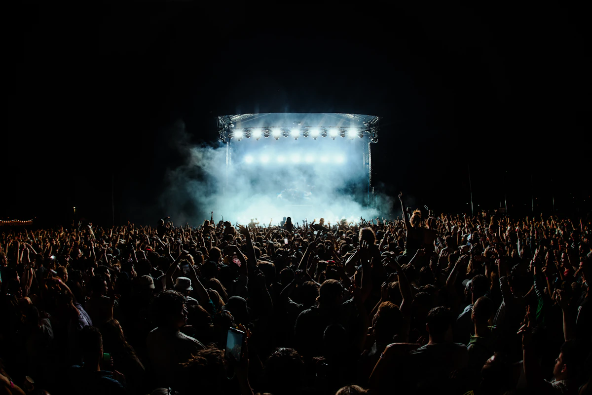 Concert stage and a silhouetted audience under blue-white lights