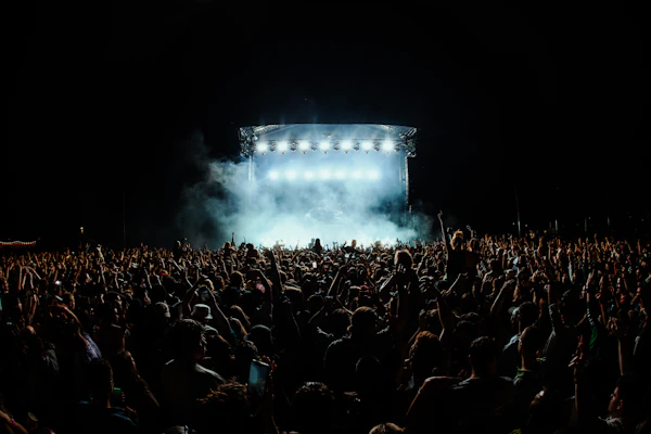 Concert stage and a silhouetted audience under blue-white lights