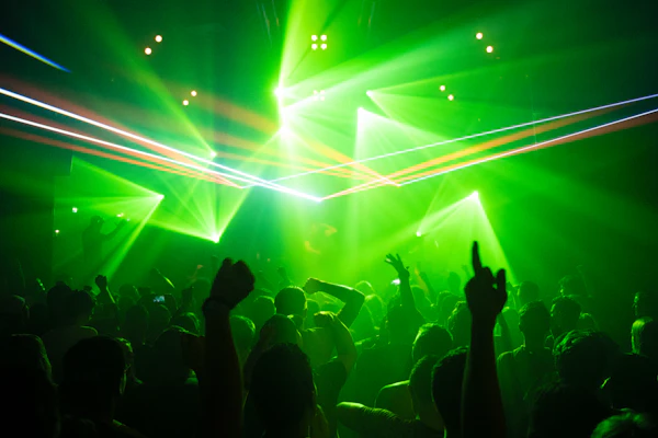 Nightclub crowd silhouetted beneath green stage lights